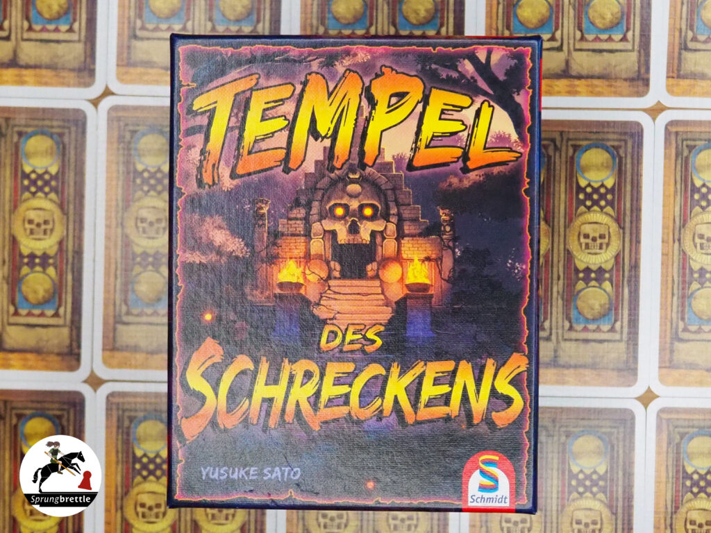 Deduktionsspiel Tempel des Schreckens mittig. Orange Gelber Titel in Großbuchstaben. Im Hintergrund ein Tempeleingang mit einer Totenkopftür mit leuchtend gelben Augen.
