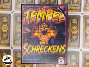 Deduktionsspiel Tempel des Schreckens mittig. Orange Gelber Titel in Großbuchstaben. Im Hintergrund ein Tempeleingang mit einer Totenkopftür mit leuchtend gelben Augen.