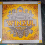 Winzul in der Tischmitte. Hauptsächlich gelbe Farben mit grauem Rand auf Spielfeld mit detailliert illustriertem Dschungel-Thema.