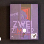 Zwei Zimmer Spielschachtel auf schwarzem Hintergrund.